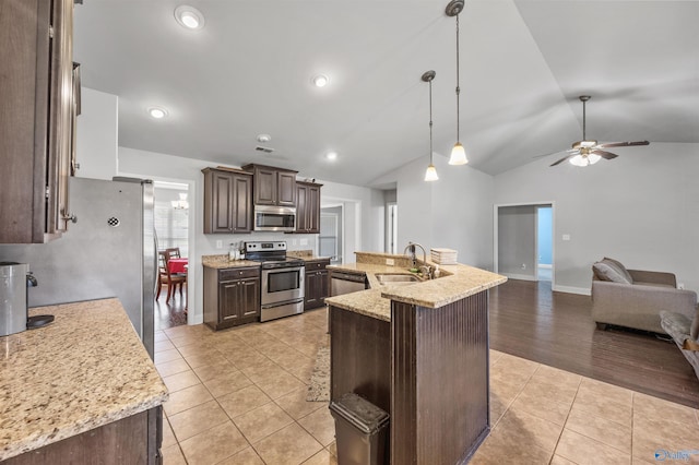 kitchen with sink, hanging light fixtures, light tile patterned floors, dark brown cabinetry, and stainless steel appliances