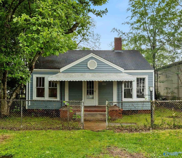 view of front of home with roof with shingles, a chimney, a porch, and a fenced front yard