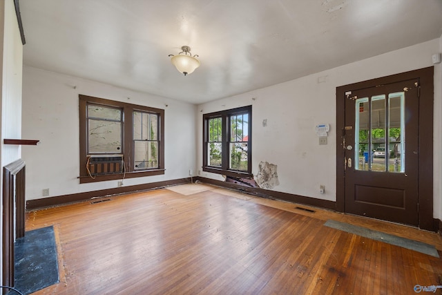 foyer entrance with baseboards, visible vents, and hardwood / wood-style flooring