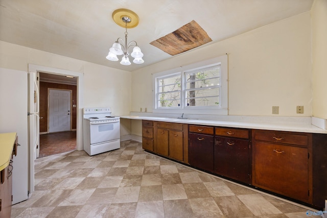 kitchen with hanging light fixtures, a notable chandelier, a sink, white appliances, and light countertops