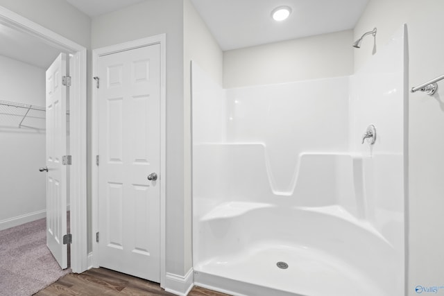 bathroom featuring hardwood / wood-style flooring and walk in shower