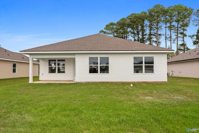 rear view of property featuring a patio and a lawn