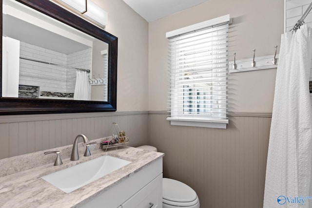 bathroom featuring curtained shower, vanity, and toilet