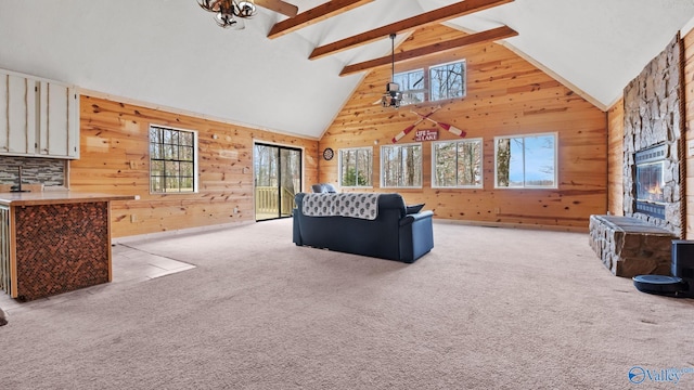 living room featuring wood walls, light colored carpet, and a healthy amount of sunlight