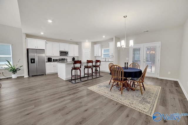 dining room featuring a notable chandelier and light hardwood / wood-style flooring