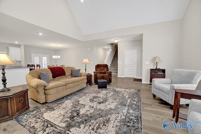 living room featuring high vaulted ceiling and light hardwood / wood-style floors