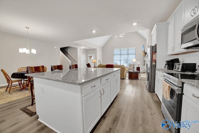 kitchen with white cabinetry, appliances with stainless steel finishes, and a kitchen bar