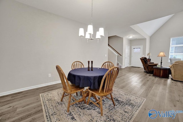 dining room featuring lofted ceiling, a chandelier, and hardwood / wood-style floors