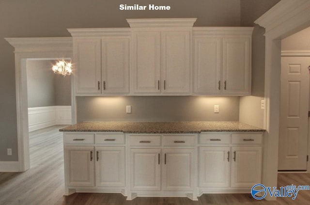 kitchen featuring light stone countertops, white cabinetry, and light wood finished floors