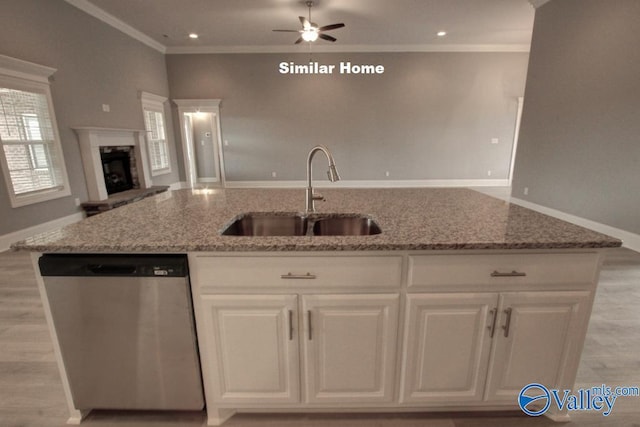 kitchen with a sink, white cabinets, open floor plan, and dishwasher