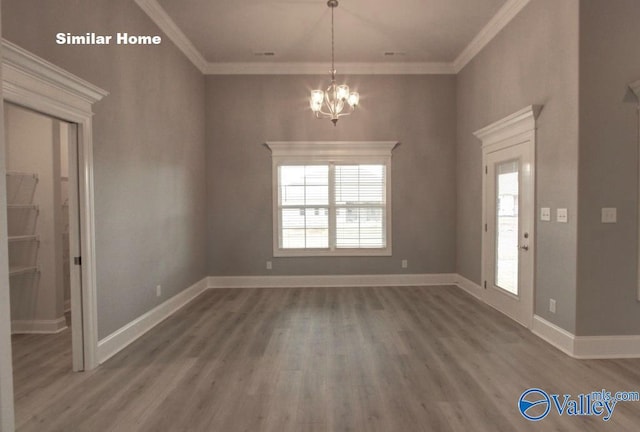 unfurnished dining area with baseboards, ornamental molding, wood finished floors, and a notable chandelier