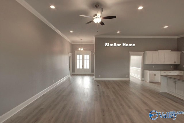 unfurnished living room featuring a ceiling fan, crown molding, baseboards, and wood finished floors