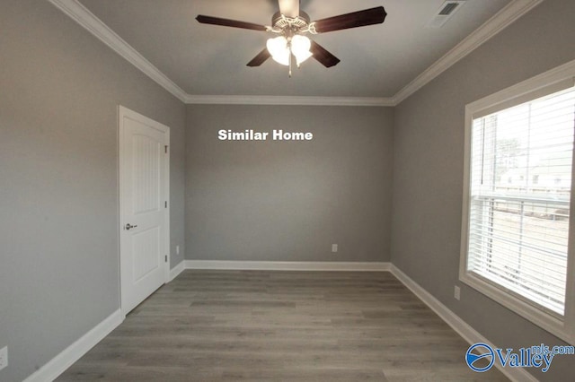 empty room featuring dark wood-style floors, visible vents, ornamental molding, ceiling fan, and baseboards