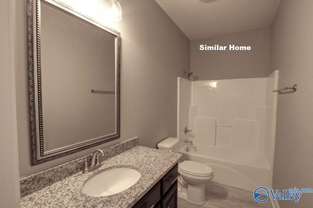 bathroom featuring toilet, vanity, and shower / tub combination