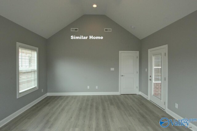 spare room featuring light wood-type flooring, visible vents, and baseboards