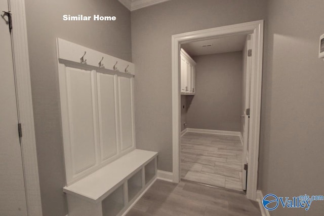 mudroom featuring light wood-type flooring and baseboards