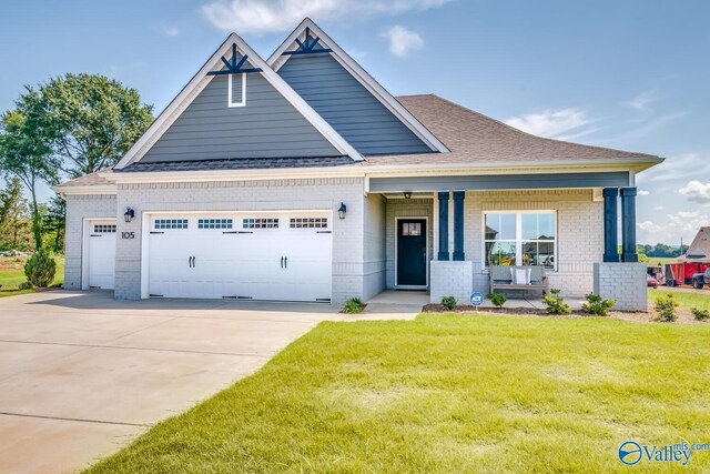 craftsman-style home featuring covered porch, a garage, and a front lawn