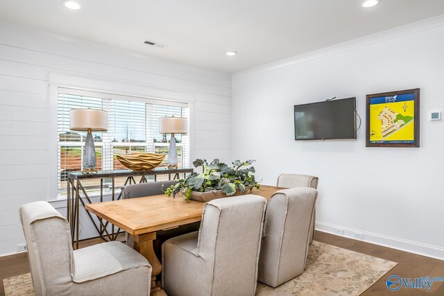 dining space with plenty of natural light, crown molding, and wood-type flooring