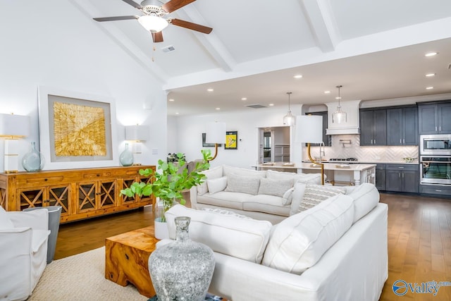 living room featuring beam ceiling, dark hardwood / wood-style flooring, high vaulted ceiling, and ceiling fan