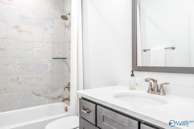 full bathroom with vanity, shower / tub combo with curtain, and toilet