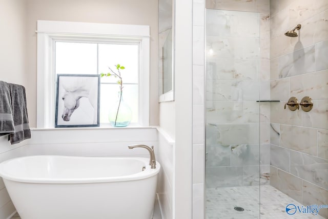 bathroom with shower with separate bathtub and a wealth of natural light