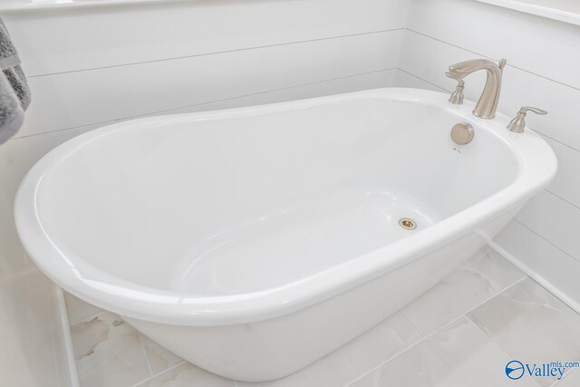 bathroom with a tub and tile patterned floors