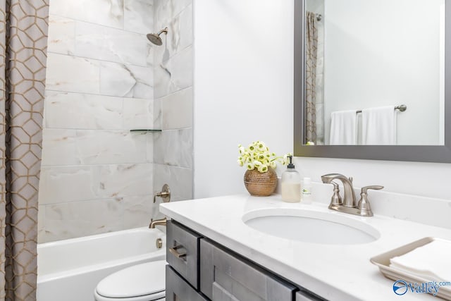 full bathroom featuring tiled shower / bath combo, toilet, and vanity