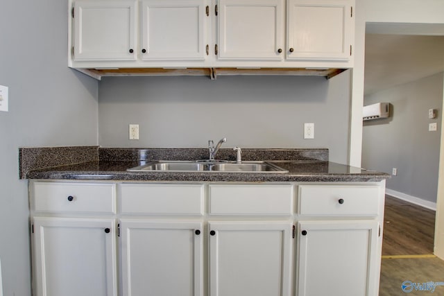 kitchen with white cabinetry, sink, and wood-type flooring