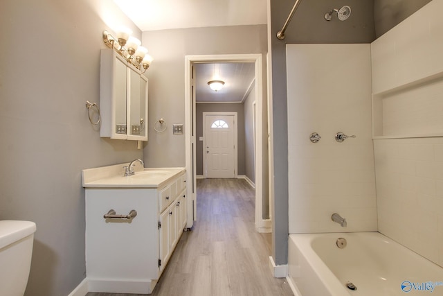 full bathroom featuring tub / shower combination, vanity, wood-type flooring, ornamental molding, and toilet