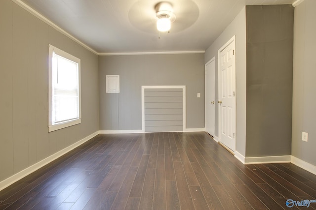 spare room featuring dark hardwood / wood-style flooring and crown molding