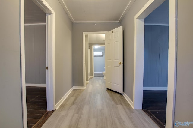 hallway featuring crown molding, an AC wall unit, and light hardwood / wood-style flooring