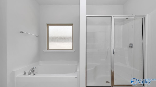 bathroom featuring shower with separate bathtub