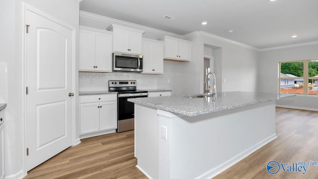 kitchen featuring white cabinetry, appliances with stainless steel finishes, a center island with sink, and light wood-type flooring