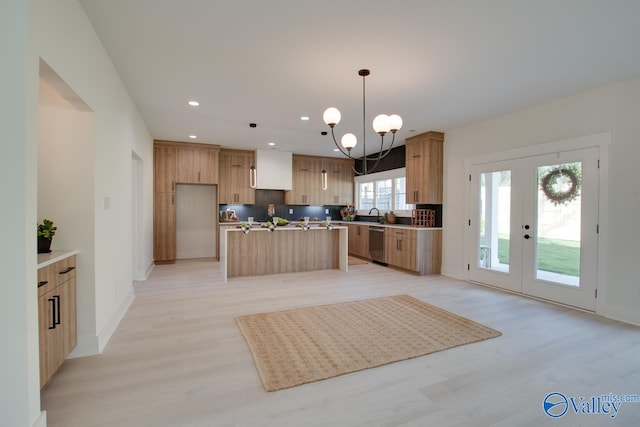 kitchen with an inviting chandelier, light hardwood / wood-style flooring, stainless steel dishwasher, backsplash, and a kitchen island