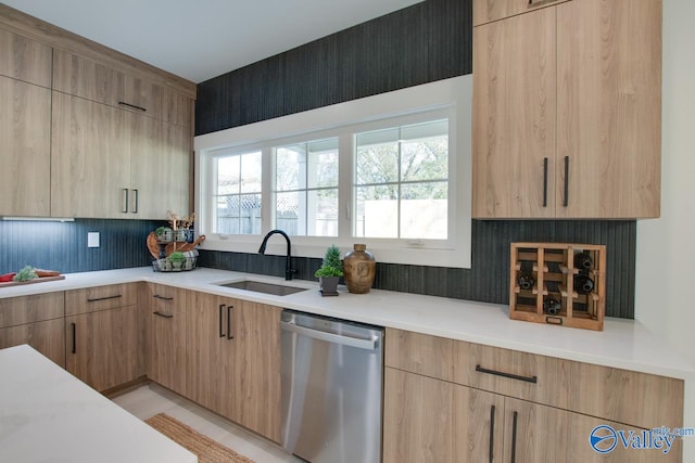 kitchen with stainless steel dishwasher, light brown cabinets, and sink