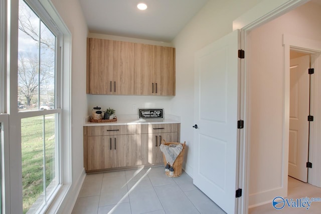 kitchen featuring light tile patterned floors and light brown cabinetry