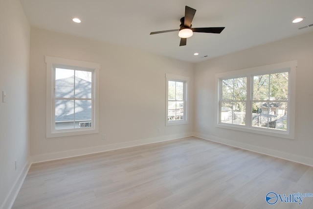 spare room with ceiling fan, a healthy amount of sunlight, and light hardwood / wood-style floors