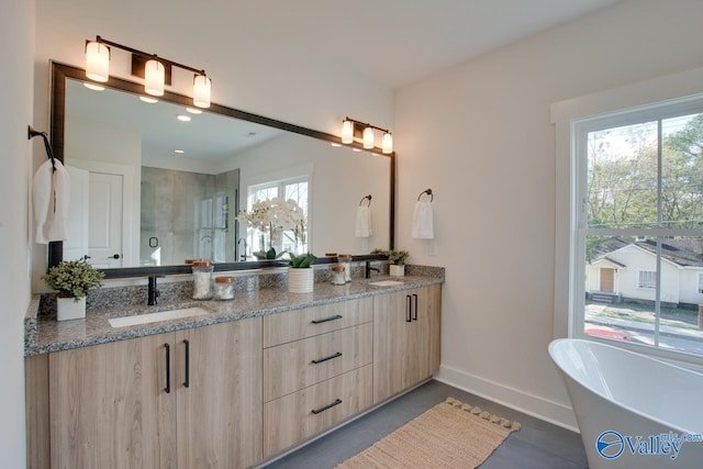 bathroom featuring plus walk in shower, vanity, and a wealth of natural light