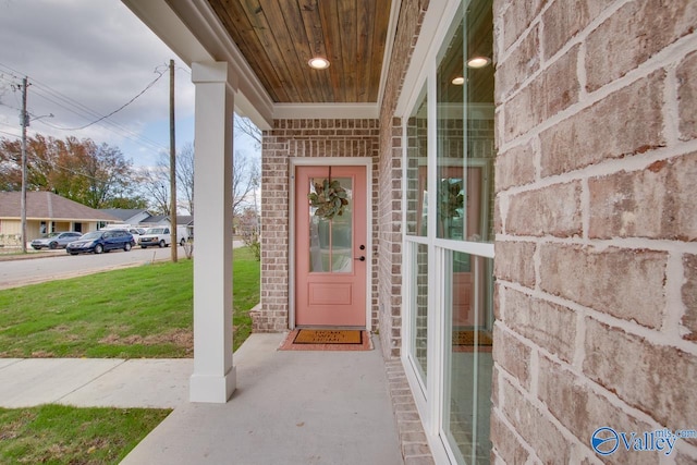 view of exterior entry featuring a lawn