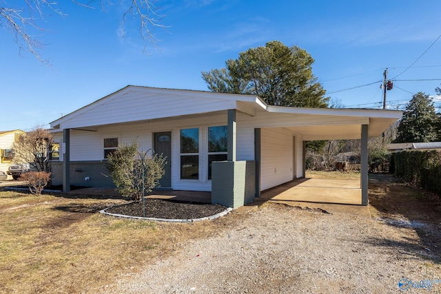 exterior space featuring brick siding, fence, and dirt driveway