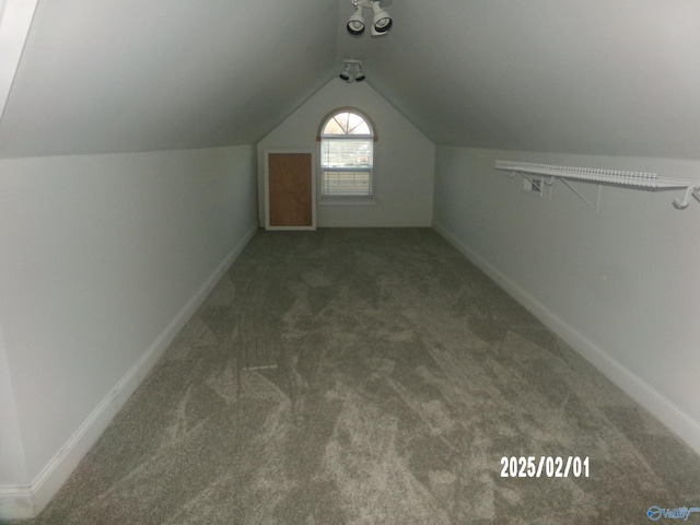 bonus room featuring vaulted ceiling and dark carpet