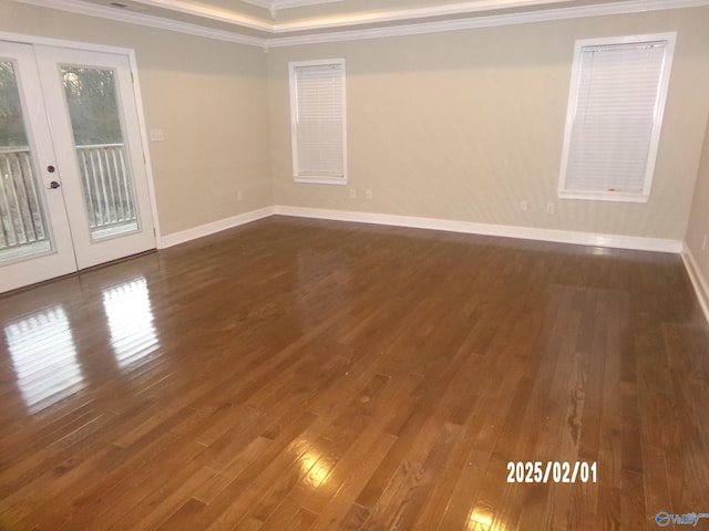 empty room with crown molding, dark wood-type flooring, and french doors