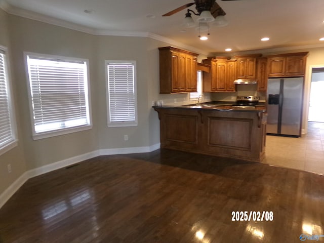 kitchen featuring sink, ornamental molding, appliances with stainless steel finishes, dark hardwood / wood-style floors, and kitchen peninsula