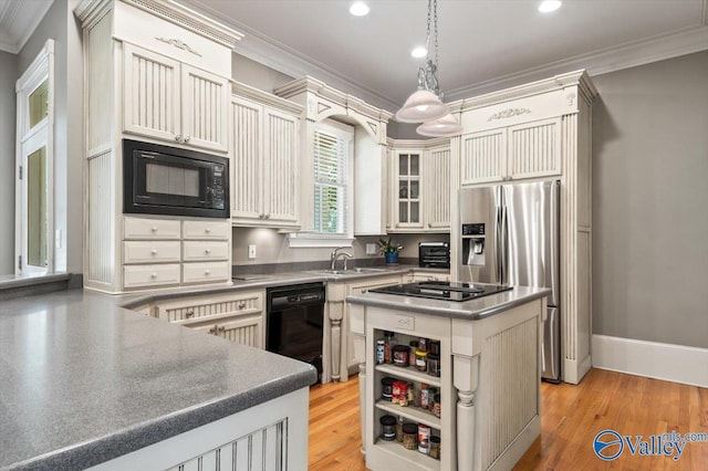 kitchen with a center island, a sink, black appliances, ornamental molding, and recessed lighting