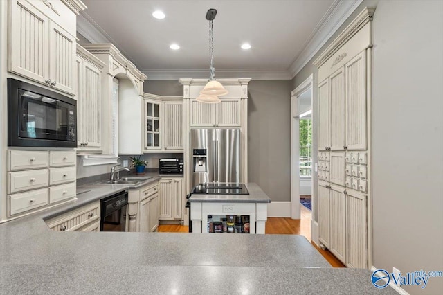 kitchen featuring ornamental molding, a sink, pendant lighting, black appliances, and glass insert cabinets