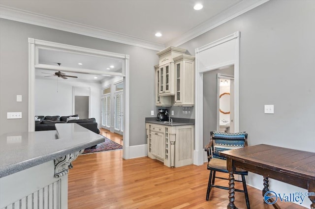 kitchen with a ceiling fan, light wood-style floors, glass insert cabinets, cream cabinetry, and recessed lighting