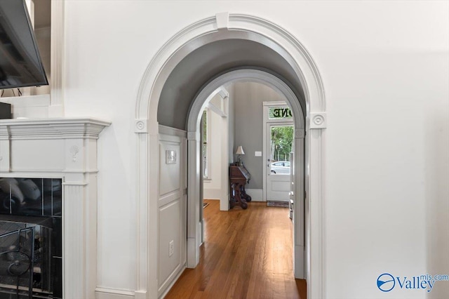 hallway with wood finished floors and arched walkways