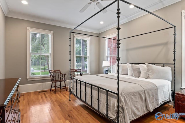 bedroom with recessed lighting, wood finished floors, visible vents, crown molding, and baseboards