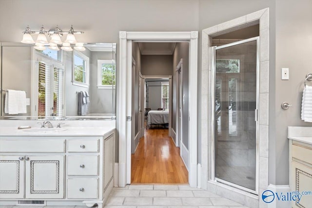 ensuite bathroom featuring a shower stall, visible vents, vanity, crown molding, and ensuite bathroom