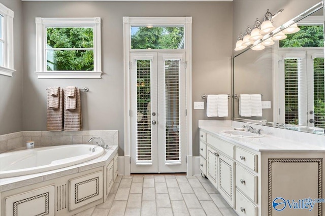bathroom with a bath, vanity, and tile patterned floors